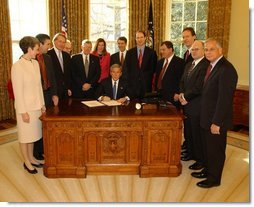 President George W. Bush pauses before signing the Controlling the Non-Solicited Pornography and Marketing Act of 2003, which establishes a framework of administrative, civil and criminal tools to help Americas consumers, businesses and families combat SPAM, in the Oval Office Tuesday, Dec. 16, 2003. Pictured with the President are from left to right: Rep. Heather Wilson, (R, NM); Garry Betty, President and CEO of Earthlink; Rep. Edward Markey (D, MA); Rep. Rick Boucher (D, VA); Sen. Conrad Burns (R, MT); Rep. Melissa Hart (R, PA; Sen. Bill Frist (R, TN); Sen. Ron Wyden (D, OR); Rep. Chris Cannon (R, UT); Jonathan Miller, Chairman and CEO of America Online; Maynard Webb, Chief Operating Officer of eBay; Rep. Gene Green (D, TX). White House photo by Tina Hager.